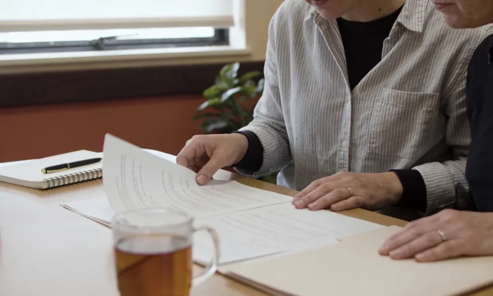 A support coordinator and a participant going through paperwork together at a table in an Australian community centre.